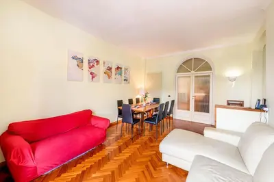 a living room with a red couch and a table at Viale Mazzini Big Apartment in Rome