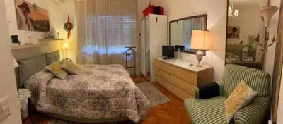 a bedroom with a bed and a desk and a chair at A Casa di Silvana in Rome