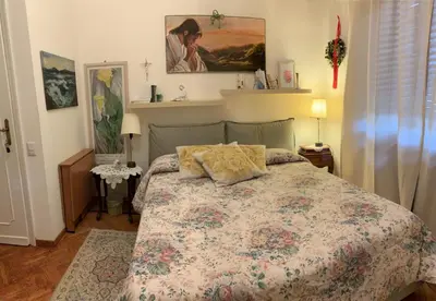 a bedroom with a bed with a floral bedspread at A Casa di Silvana in Rome