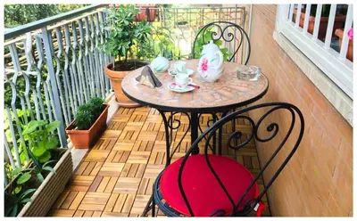 a table and chairs on a balcony with plants at A Casa di Silvana in Rome
