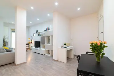 a white living room with a table and a couch at Ponte Milvio Holiday Home in Rome