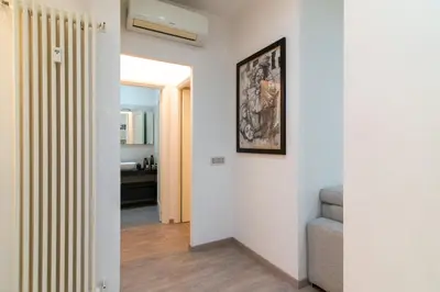 a hallway with white walls and a staircase with a picture at Ponte Milvio Holiday Home in Rome