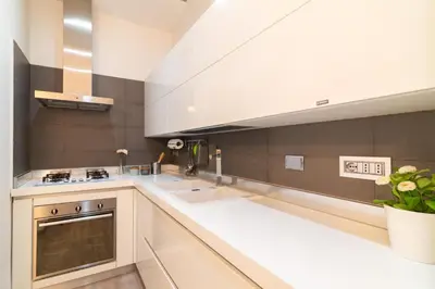 a large kitchen with white counters and a large window at Ponte Milvio Holiday Home in Rome