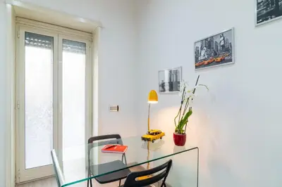 a dining room with a glass table and two chairs at Ponte Milvio Holiday Home in Rome