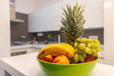 a green bowl of fruit on a counter in a kitchen at Ponte Milvio Holiday Home in Rome