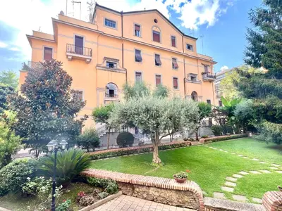a large building with a garden in front of it at The Stylish at Ponte Milvio in Rome
