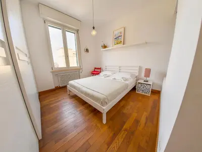 a bedroom with a bed and a wooden floor at Stunning 3-Bedroom Penthouse in Rome