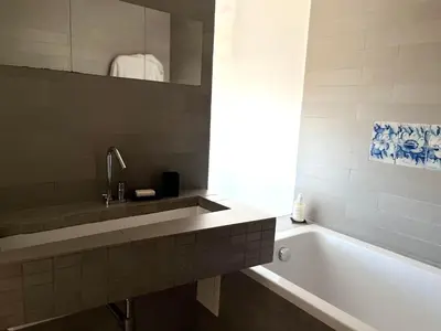 a bathroom with a sink and a bath tub at Stunning 3-Bedroom Penthouse in Rome