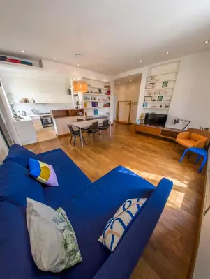 a living room with a blue couch with pillows at Stunning 3-Bedroom Penthouse in Rome