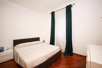 a bedroom with a bed and a window with green curtains at Yellowmat by Ghor in Rome