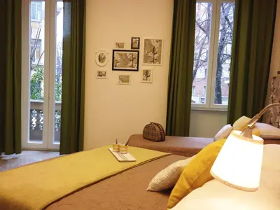 a bedroom with a bed with a yellow blanket and windows at Domò Vaticano Guest House in Rome
