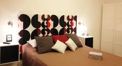 a bedroom with a bed with a large headboard at Domò Vaticano Guest House in Rome