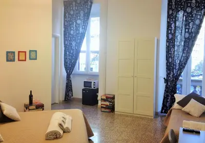a bedroom with two beds and a door with curtains at Domò Vaticano Guest House in Rome