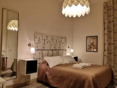 a bedroom with a bed and two lamps and a mirror at Domò Vaticano Guest House in Rome