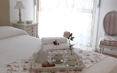 a white bed with a tray with tea sets on it at L'Incantevole Aventino in Rome