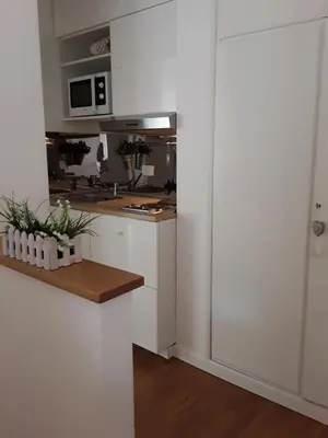a kitchen with white cabinets and a counter top at L'Incantevole Aventino in Rome