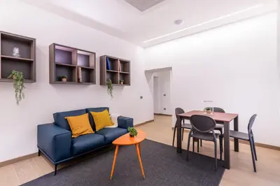 a living room with a blue couch and a table at JOIVY Cavour 238 in Rome