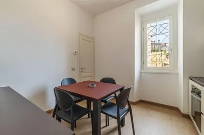 a dining room with a table and chairs and a window at JOIVY Cavour 238 in Rome