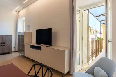 a living room with a tv and a large window at JOIVY Cavour 238 in Rome