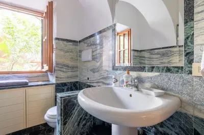 a bathroom with a sink and a toilet and a window at Residenza Latina -Charme & Relax in Rome