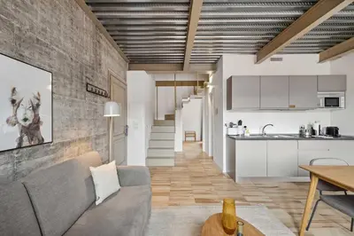 a living room with a couch and a kitchen at Limehome Rome Via Fortebraccio in Rome