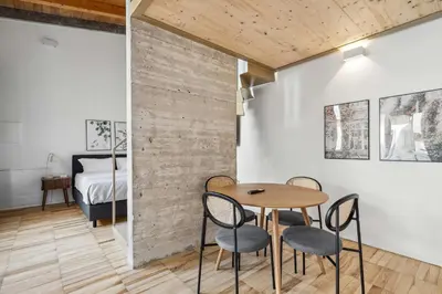 a room with a table and chairs and a bedroom at Limehome Rome Via Fortebraccio in Rome