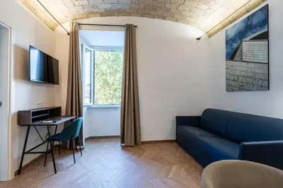 a bedroom with a white bed with two pillows at Urban Vatican Rooms in Rome