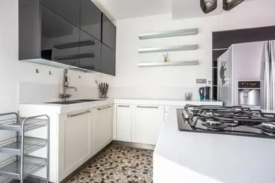 a white kitchen with black cabinets and a stove at Charme & Luxe 2 bedroom apartment City Center in Rome