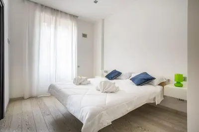 a white bedroom with a large white bed with blue pillows at Charme & Luxe 2 bedroom apartment City Center in Rome