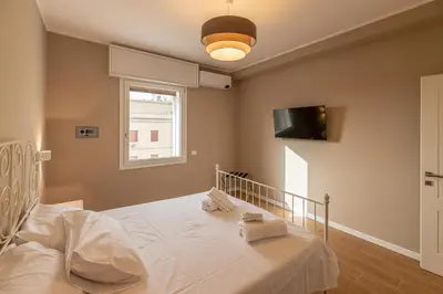 a bedroom with a bed and a tv on the wall at Romanamente Suite in Rome