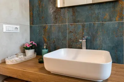 a white sink on a wooden counter in a bathroom at Romanamente Suite in Rome