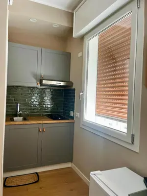 a kitchen with a window with a blind on it at Romanamente Suite in Rome