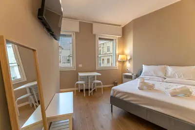 a bedroom with a bed and a mirror and a table at Romanamente Suite in Rome