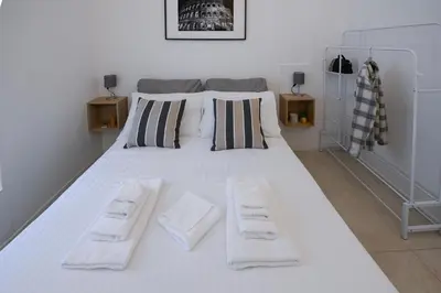 a large white bed with two towels on it at Ferrari 12 Apartment - Vaticano in Rome