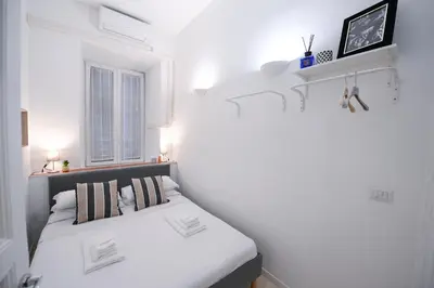 a white bedroom with a bed and a window at Ferrari 12 Apartment - Vaticano in Rome
