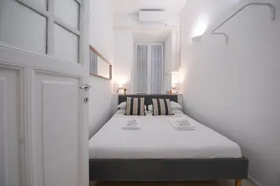 a small bedroom with a bed in a white room at Ferrari 12 Apartment - Vaticano in Rome