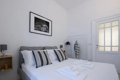 a white bed with two towels on top of it at Ferrari 12 Apartment - Vaticano in Rome
