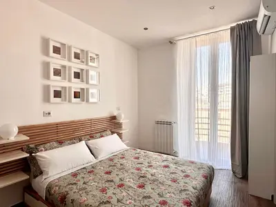 a bedroom with a bed and a large window at MuMo Home - San Giovanni in Rome