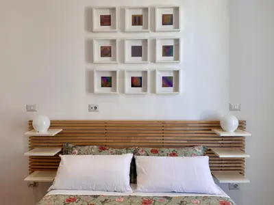 a bedroom with a bed and some pictures on the wall at MuMo Home - San Giovanni in Rome