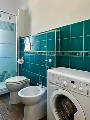 a bathroom with a washing machine and a toilet at MuMo Home - San Giovanni in Rome