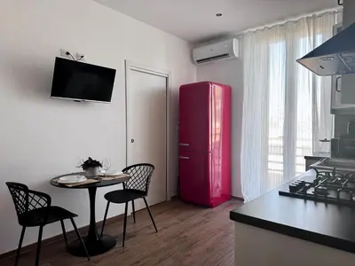 a kitchen with a red refrigerator and a table and chairs at MuMo Home - San Giovanni in Rome