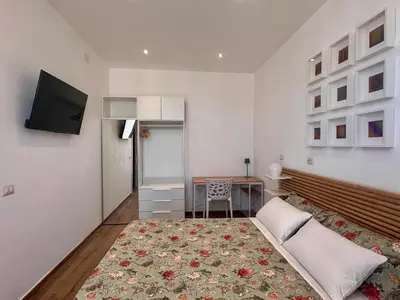 a bedroom with a bed and a table and a television at MuMo Home - San Giovanni in Rome