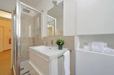 a white bathroom with a sink and a shower at Doria in Rome