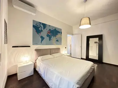a bedroom with a white bed and a map on the wall at Casa Vacanze Secret Garden in Rome