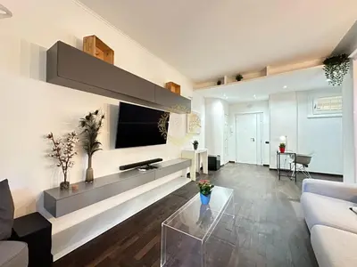 a living room with a couch and a tv on a wall at Casa Vacanze Secret Garden in Rome