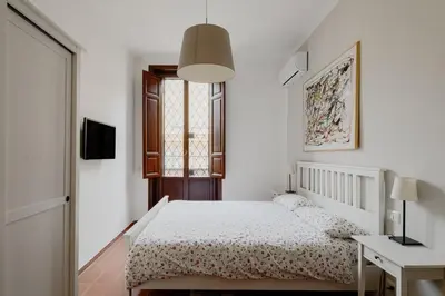 a white bedroom with a bed and a window at Borgo Pio Holiday in Rome