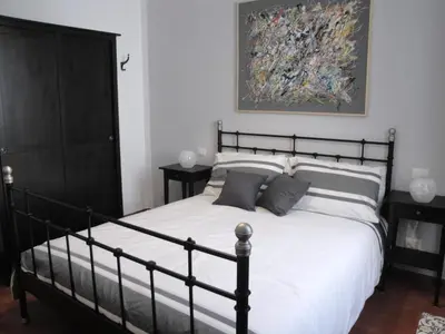a bedroom with a black and white bed and a painting at Borgo Pio Holiday in Rome