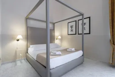 a bedroom with a canopy bed with white sheets at Navona New Deluxe Apartment in Rome