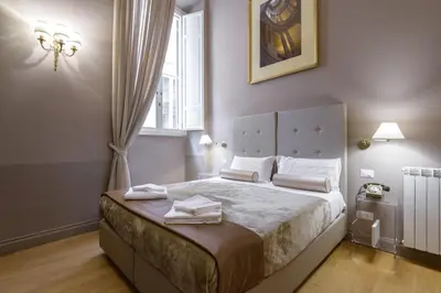 a bedroom with a bed with white sheets and a window at Navona New Exclusive Apartment in Rome