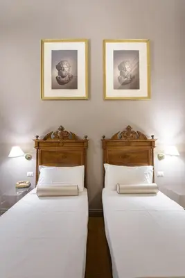 two beds in a room with two pictures on the wall at Navona New Exclusive Apartment in Rome